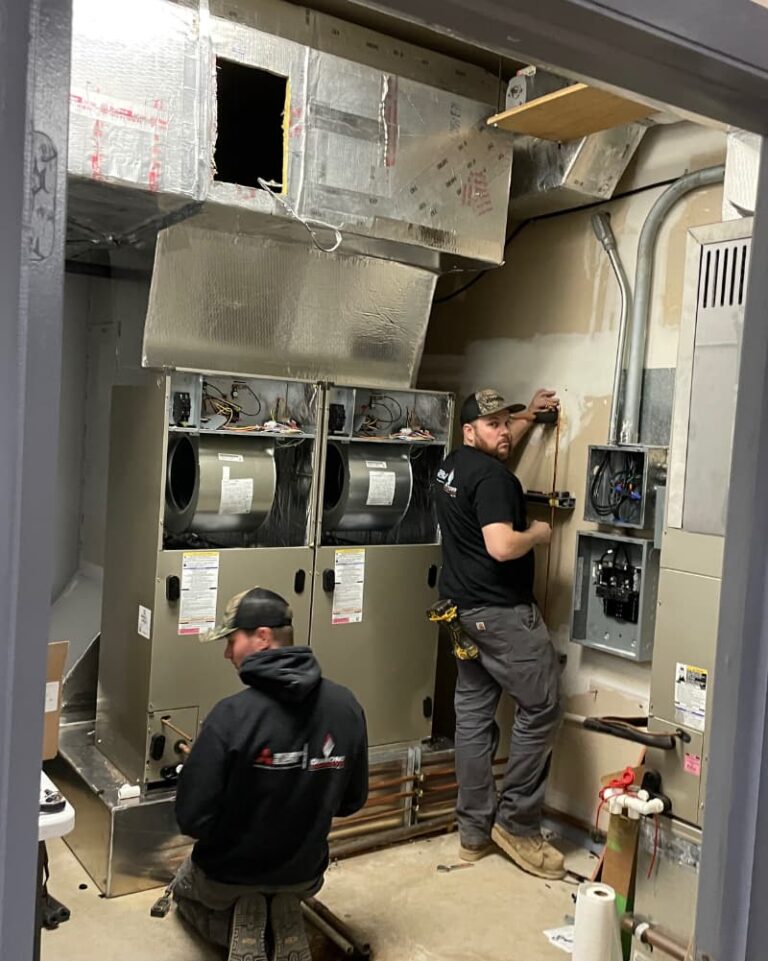 two hvac techs working on commercial hvac equipment from mgm mechanical