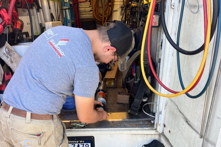mgm mechanical service tech working on hvac in the back of a service truck